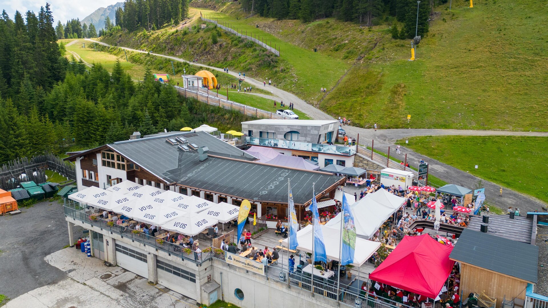 A popular mountain restaurant with a large terrace and many guests. Surrounded by forests and mountains, it offers a beautiful view. | © Christian Barz