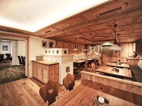 A cozy restaurant with wooden furnishings and warm lighting. The walls and ceilings are made of wood, creating an inviting atmosphere.