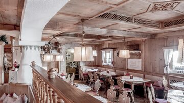 A cozy restaurant with wooden decor and comfortable tables. Warm lighting creates an inviting atmosphere.