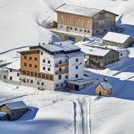 Ein schönes, schneebedecktes Bergdorf mit mehreren Häusern. Die Umgebung ist ruhig und malerisch.