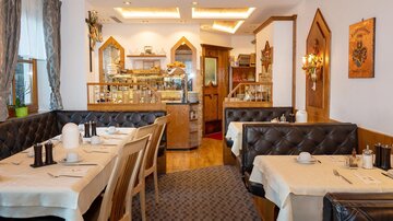 A cozy restaurant with elegant tables and stylish interior. The atmosphere is inviting and warmly designed.