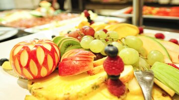 A colorful fruit platter with various fruits including apples, grapes, pineapples, and berries. Beautifully decorated, it offers a variety of flavors and colors.