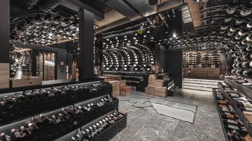 An elegant wine cellar with a variety of wine bottles. The walls are stylishly designed, and the atmosphere is modern and inviting.