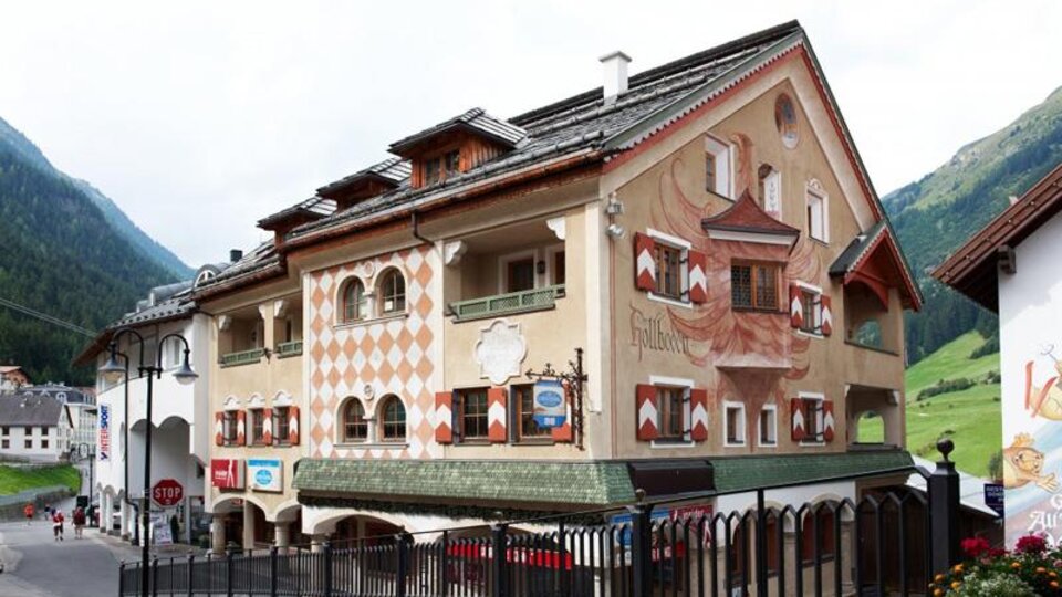 A charming building with exquisite murals in a picturesque mountain landscape. The streets are surrounded by nature, and the atmosphere is inviting.
