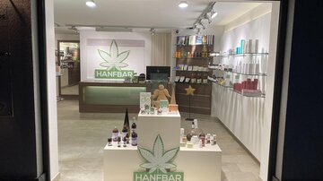 A bright, modern sales area with a focus on hemp products. Various products are displayed prominently on a pedestal.
