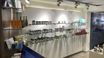 A modern store for cosmetic products with clear shelves and a variety of creams and oils. The space is brightly and invitingly designed.
