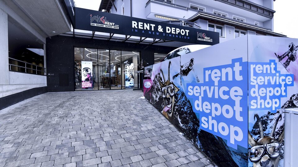 A modern business entrance with the inscription "RENT & DEPOT". The facade is colorful and invites discovery.