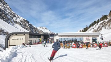 Eine moderne Skihütte in einer verschneiten Berglandschaft. Skifahrer genießen die Sonne und das klare Wetter.
