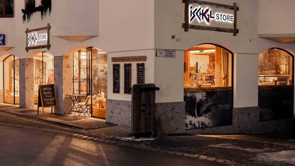 A cozy shop in a city with inviting lighting. The windows display various products and a popular shopping destination.