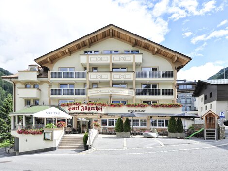 A charming hotel with alpine design and several balconies. Surrounded by mountains and a peaceful setting.