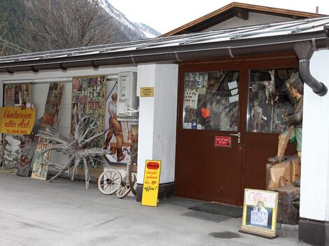 A traditional shop with wooden carvings and handicrafts. The facade displays various artworks and an inviting entrance door.