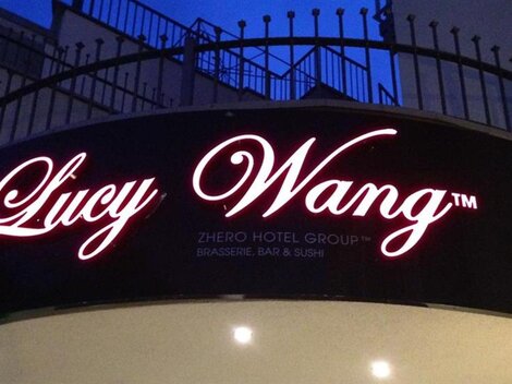A sign for the hotel "Lucy Wang" with an elegant font. The logo shines at night and attracts attention.