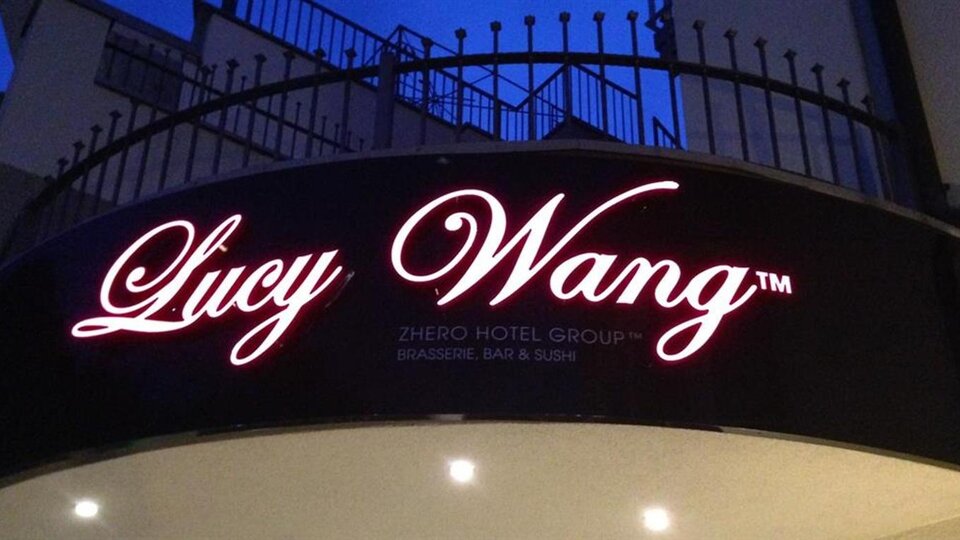 A sign for the hotel "Lucy Wang" with an elegant font. The logo shines at night and attracts attention.