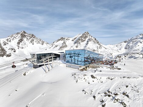 A modern mountain station in the snowy Alps. In the background, majestic mountains and a clear sky can be seen.