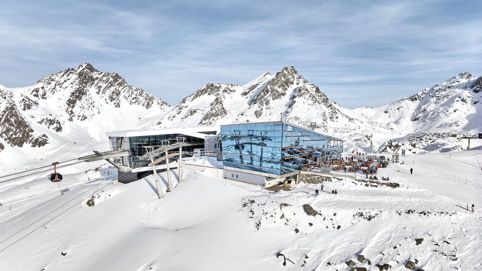 A modern mountain station in the snowy Alps. In the background, majestic mountains and a clear sky can be seen.