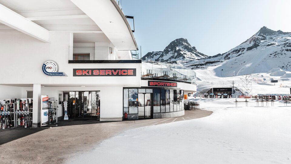 A modern ski service with large windows and a view of snow-covered mountains. The environment is characterized by a fascinating winter landscape.