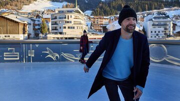 A person happily walks on an ice skating rink with mountains in the background. The surroundings are wintry and completely covered in snow. | © Silvrettaseilbahn AG