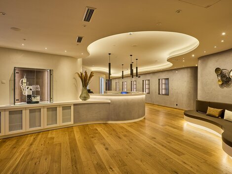 A modern reception area with stylish design and bright wooden floors. The walls are painted in soft color tones, and the lighting creates a pleasant atmosphere.