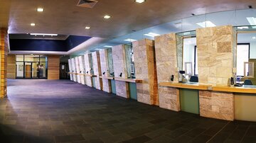 A modern-designed reception area with window displays. The room is bright and spacious, with wood and stone surfaces.