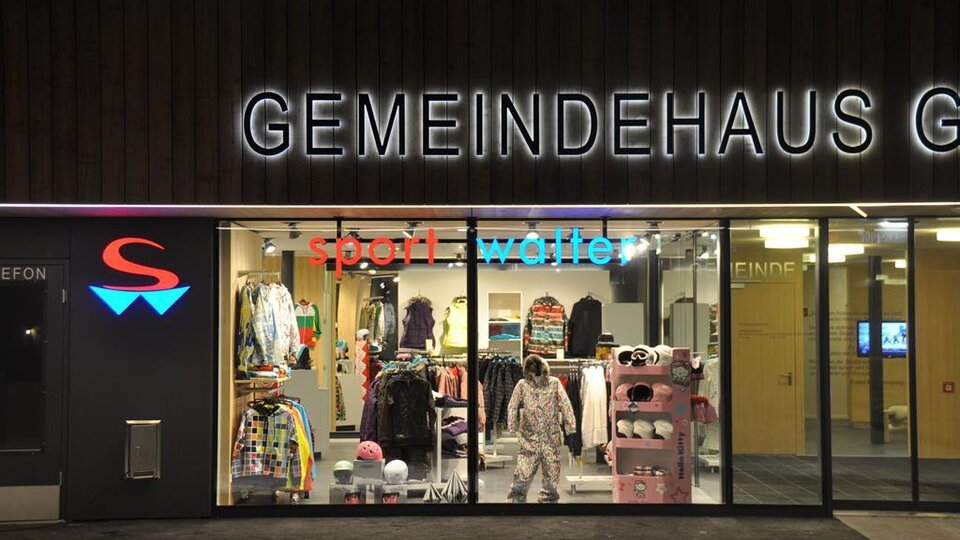 Ein Geschäft mit Sportkleidung und Accessoires ist zu sehen. Die Beleuchtung sorgt für eine einladende Atmosphäre.