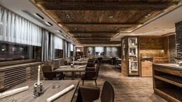 Ein modernes Restaurant mit Holzverkleidung und stilvollen Möbeln. Die Atmosphäre ist gemütlich und einladend.