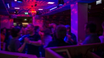 A lively party in a club with colorful lights. People are dancing and having fun in an engaging atmosphere.