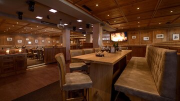 A cozy restaurant with wooden furniture and warm lighting. The atmosphere feels inviting and relaxed.