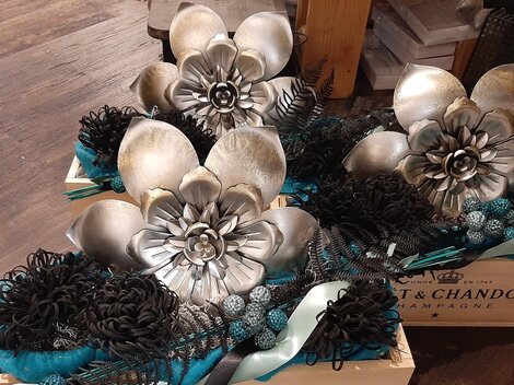 Two decorative boxes with artistic floral arrangements in silver and black. The flowers are arranged in various shapes, giving an elegant look.