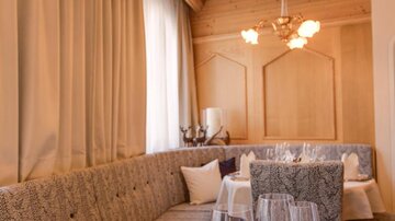 An elegant restaurant with a cozy table setting. The decor is modern with wooden details and soft colors.