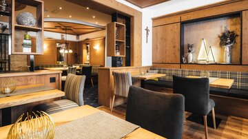 A cozy restaurant with wooden decor and stylish furniture. The warm colors create an inviting atmosphere.