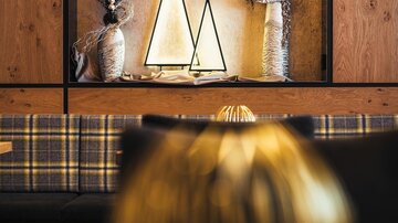 A stylish interior with decorative elements in the form of pointed triangles. In the background, dried flowers are visible in various vases.