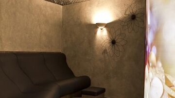 A relaxing room with a curved sofa and soft lighting. The walls are simply designed, and the starry sky gives a cozy atmosphere.