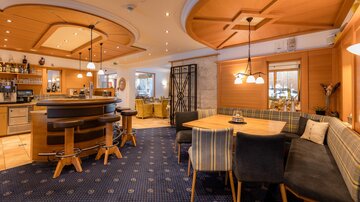 A cozy interior with a bar and light wooden elements. Comfortable seating and pleasant lighting create an inviting atmosphere.