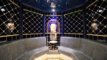 An elegant room with mosaic walls and a central fountain. The relaxing atmosphere is accentuated by soft lighting and high-quality materials.