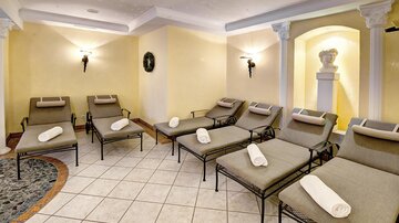 A relaxing room with comfortable loungers and soft light. The atmosphere is calm and inviting.