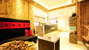 A cozy reception area with wooden paneling and modern design. On a table, there is a bowl of nuts.
