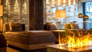Ein eleganter Wellnessbereich mit bequemen Liegen und warmem Licht. Die moderne Einrichtung sorgt für eine entspannte Atmosphäre.