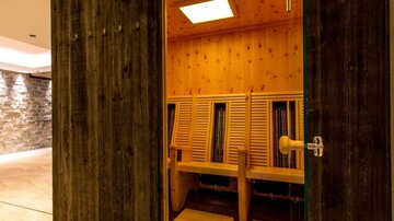 Ein moderner Saunabereich mit Holzstuhlreihen und warmem Licht. Die Atmosphäre wirkt entspannend und einladend.