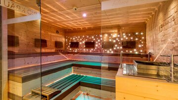 Ein modernes Spa mit Holzverkleidung und sanften Lichtern. Der Raum ist minimalistisch und einladend, ideal zur Entspannung.