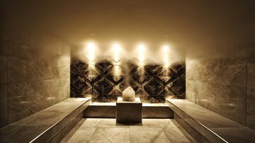 An elegant wellness room with soft lighting and modern stone surfaces. The room radiates calm and relaxation.