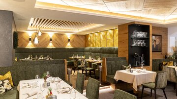 A modern restaurant with stylish seating areas and elegant table decor. The warm colors and appealing lighting create an inviting atmosphere.