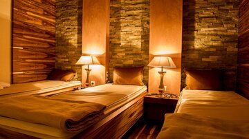A cozy bedroom with three beds. The warm wood and stone accents create an inviting atmosphere.