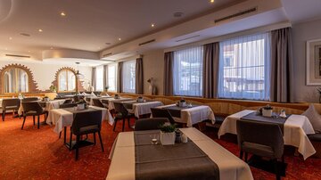 An elegant restaurant with decorated tables and chairs. Large windows let in plenty of light and create an inviting atmosphere.