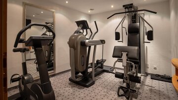 A modern gym with various training equipment. The room is well-lit and provides space for an effective workout.