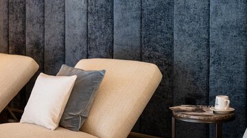An elegant relaxation area with comfortable loungers and soft lighting. The walls are in a stylish blue design.